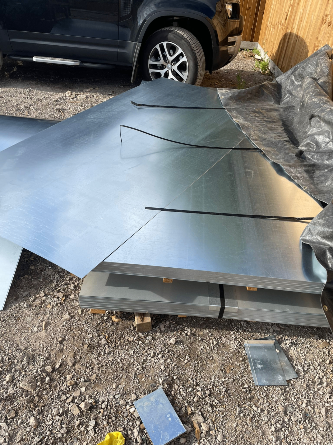 8 by 4 flat galvanised steel sheets stacked outdoors