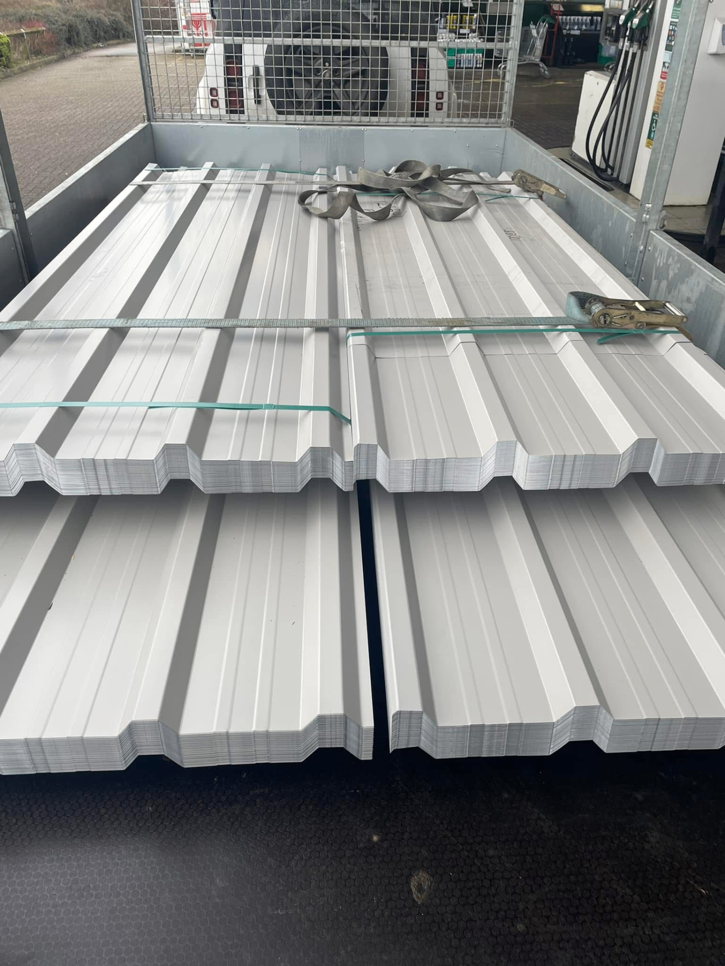 Light grey box profile roofing sheets strapped on a trailer