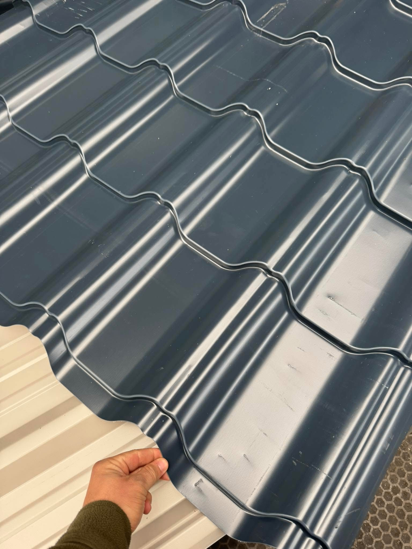 Dark grey tile effect roofing sheets stacked together