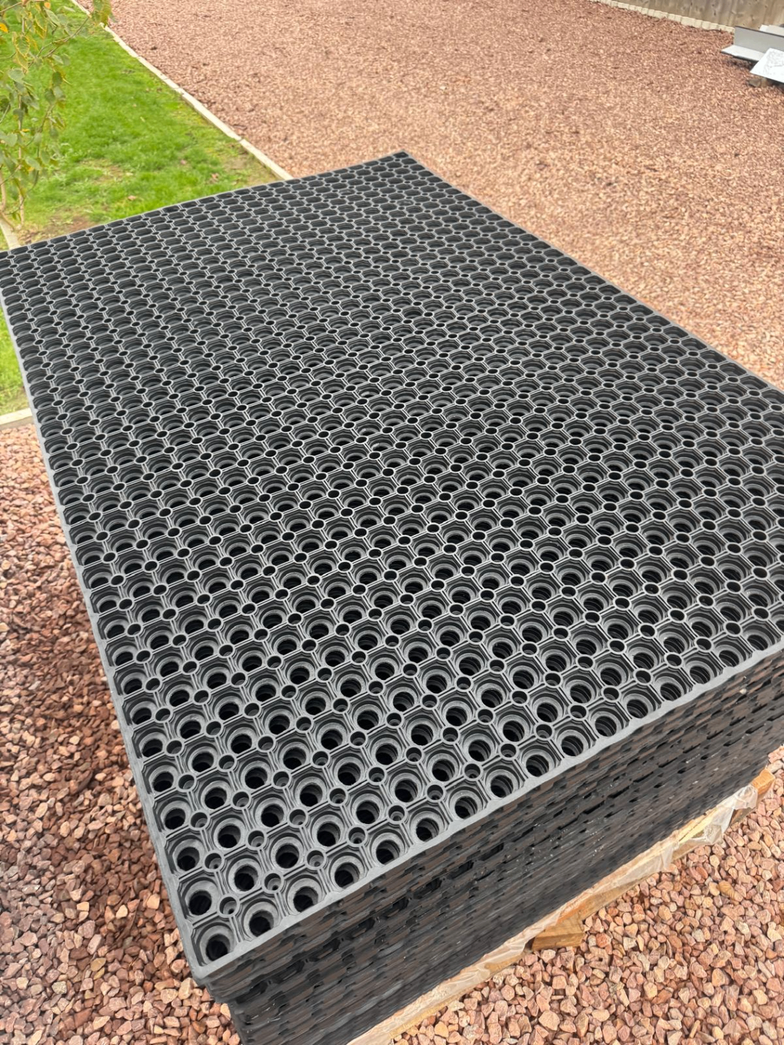 Stack of black hollow grass rubber matting sheets